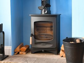 A stove with wood and a bucket in a living room at Seahorse in Filey