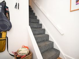 A staircase with carpet and a basket in the hallway at Seahorse in Filey
