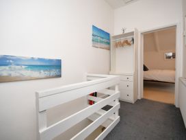 A landing area with a wardrobe and wall art at Seahorse in Filey