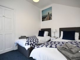 A bedroom with two beds and a painting at Seahorse in Filey