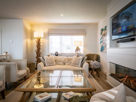 A living room with a coffee table and a TV at Calm Waters Luxury Beach House in Bridlington