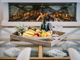 A table with a tray of fruit and champagne in the living room at Calm Waters Luxury Beach House in Bridlington