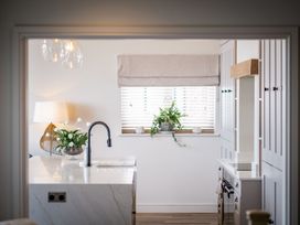 A kitchen with sink and cabinets at Calm Waters Luxury Beach House in Bridlington