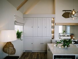 A kitchen with a cupboard and plant at Calm Waters Luxury Beach House in Bridlington