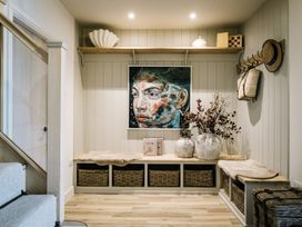 A hallway with a painting and storage baskets at Calm Waters Luxury Beach House in Bridlington