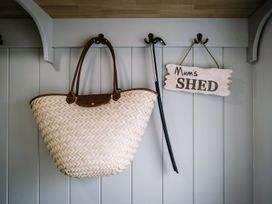 A woven bag and a Mum's Shed sign hanging on the wall at Calm Waters Luxury Beach House in Bridlington