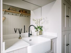 A bathroom with a sink and plant at Calm Waters Luxury Beach House in Bridlington