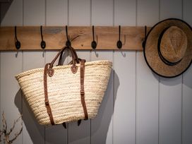 A basket and a hat hanging on hooks in the entryway at Calm Waters Luxury Beach House in Bridlington