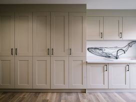 A kitchen with cabinets and a sink at Calm Waters Luxury Beach House in Bridlington