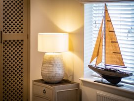 A lamp and a model sailboat in a living room at Calm Waters Luxury Beach House in Bridlington