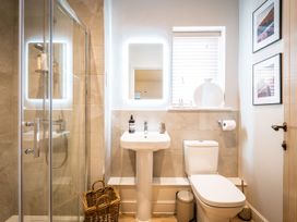 A bathroom with a shower, sink, and toilet at Calm Waters Luxury Beach House in Bridlington