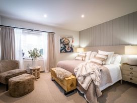 A bedroom with a bed and two chairs at Calm Waters Luxury Beach House in Bridlington