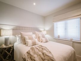 A bedroom with a bed and bedside table at Calm Waters Luxury Beach House in Bridlington