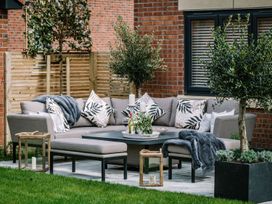 A garden with an outdoor sofa and coffee table at Calm Waters Luxury Beach House in Bridlington