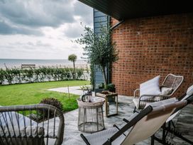 An outdoor seating area with chairs and a table at Calm Waters Luxury Beach House, Bridlington