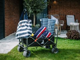 A wagon with bags and towels in a garden at Calm Waters Luxury Beach House in Bridlington