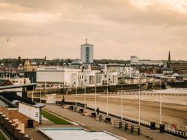 An outdoor view of beach and buildings at Calm Waters Luxury Beach House in Bridlington
