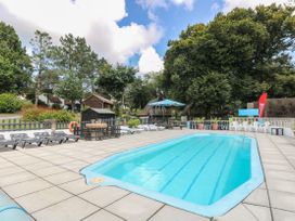 An outdoor area with a swimming pool and sun loungers at 21 Tamar & St. Anns Cottages, Honicombe Park near St. Ann's Chapel, Cornwall