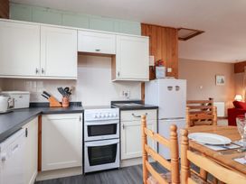 A kitchen with cooking appliances and dining table at 21 Tamar & St. Anns Cottages Honicombe Park near St. Ann's Chapel, Cornwall