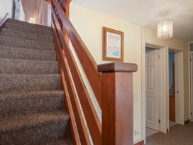 A staircase with wooden railing in a hallway at 21 Tamar & St. Anns Cottages, Honicombe Park near St. Ann's Chapel, Cornwall