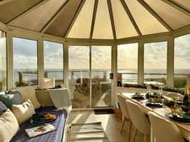 A conservatory with seating and a dining table at Crows Nest Dawlish