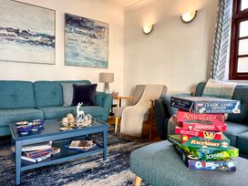 A living room with a sofa and games on a coffee table at Crows Nest Dawlish