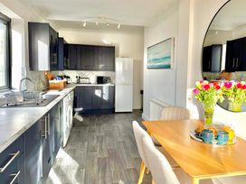A kitchen with appliances and dining area at Crows Nest Dawlish