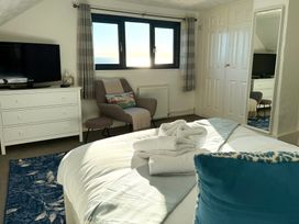 A bedroom with a bed and television at Crows Nest Dawlish