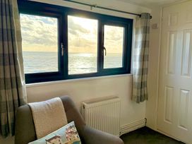 A living room with a window facing the ocean at Crows Nest Dawlish
