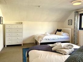 A bedroom with two beds and a dresser at Crows Nest Dawlish
