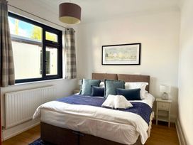 A bedroom with a bed and bedside table at Crows Nest Dawlish