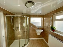 A bathroom with a shower and a wash basin at Crows Nest Dawlish