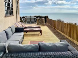 An outdoor area with seating and a table at Crows Nest Dawlish