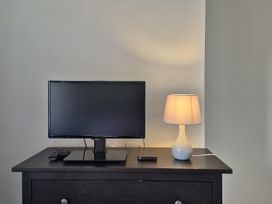 A television and lamp on a table at 54 swallow road