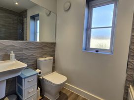 A bathroom with a toilet, sink, and window at 54 swallow road