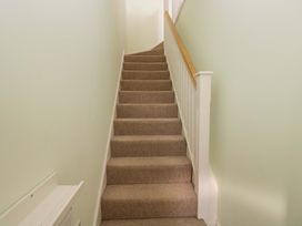 A staircase with carpet and a handrail at Swallows Nest in Bourton-On-The-Water