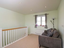 A landing with a sofa and a window at Swallows Nest in Bourton-On-The-Water