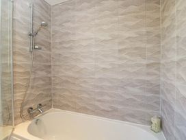 A bathroom with a bath tub and shower at Swallows Nest in Bourton-On-The-Water