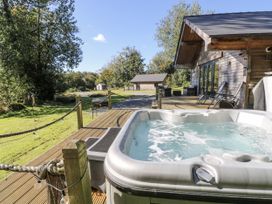 A hot tub on decking in an outdoor area at Cadno in Llanybydder