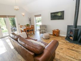 A living room with a sofa a dining table and a fireplace at Cadno in Llanybydder