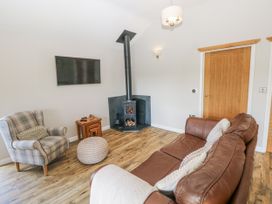 A living room with a stove and furniture at Cadno in Llanybydder