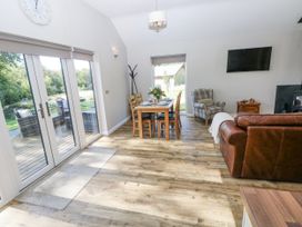 A living room with a sofa and dining table at Cadno Llanybydder