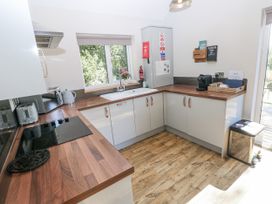 A kitchen with a sink and appliances at Cadno in Llanybydder