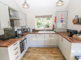 A kitchen with appliances and a window view at Cadno in Llanybydder