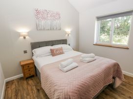 A bedroom with a bed and window at Cadno in Llanybydder