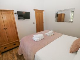 A bedroom with a bed and wardrobe at Cadno in Llanybydder