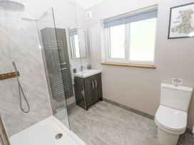 A bathroom with a shower, sink, and toilet at Cadno in Llanybydder