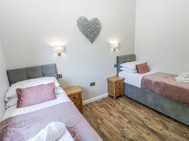 A bedroom with two beds and a heart decoration at Cadno in Llanybydder
