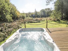 A hot tub overlooking a garden at Cadno in Llanybydder