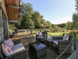 A deck with seating and a hot tub at Cadno Llanybydder